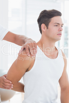 Doctor stretching a young man arm