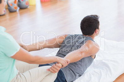 Man stretching with his trainer