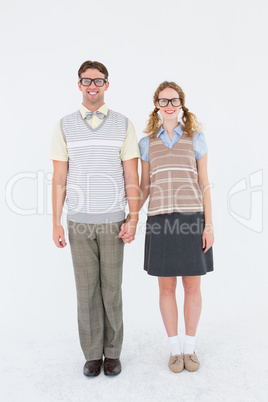 Smiling geeky hipster couple holding hands