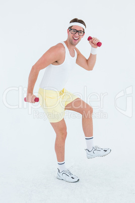 Geeky hipster lifting dumbbells in sportswear