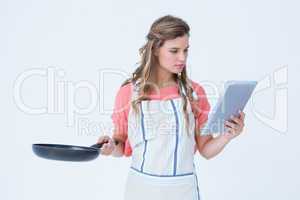 Happy hipster woman holding laptop and frying pan