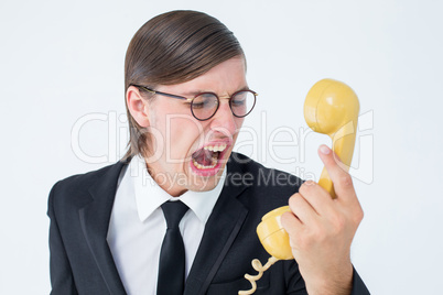 Geeky businessman shouting at retro phone