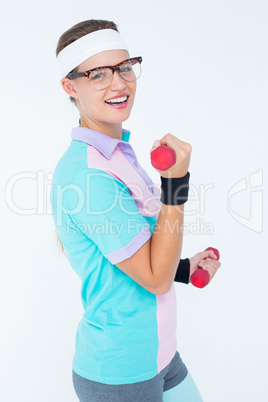 Geeky hipster girl lifting dumbbells