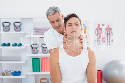 Doctor massaging a young man neck