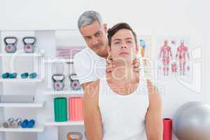Doctor massaging a young man neck