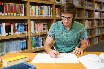 Student sitting in library writing