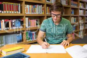 Student sitting in library writing