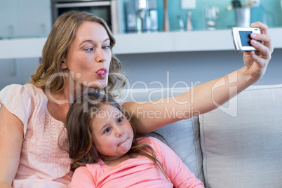 Happy mother and daughter taking selfie