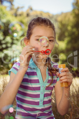Cute little girl blowing bubbles