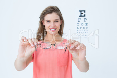 Hipster showing glasses next to an eye test