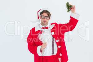 Geeky hipster in santa costume holding mistletoe