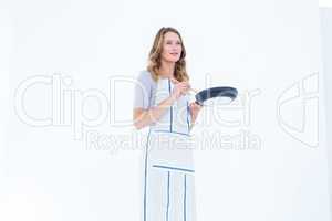 Smiling woman holding frying pan and wooden spoon