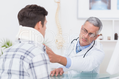 Doctor examining patient wearing neck brace