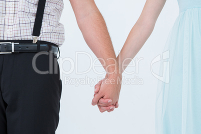 Hipster couple standing hand in hand