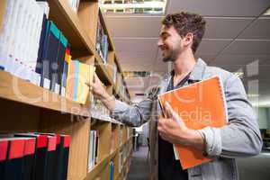 Student picking a book from shelf in library