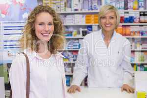 Smiling pharmacist and customer discussing a product