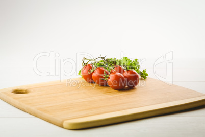 Cherry tomatoes and parsley on chopping board