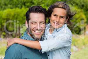 Father and son smiling at camera