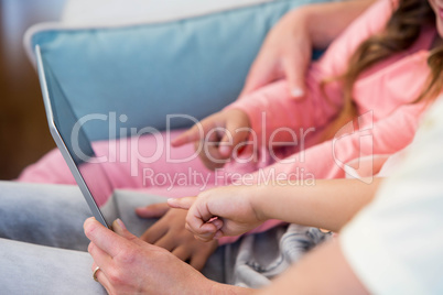 Family on the couch together using tablet pc