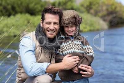 Happy casual father and son at a lake