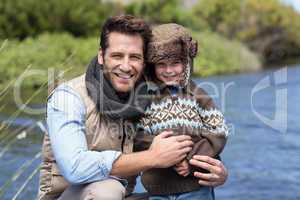 Happy casual father and son at a lake