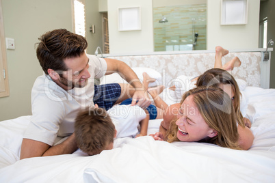 Happy family playing on the bed