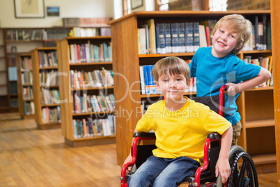 Cute pupils smiling at camera at the library