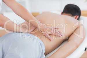 Physiotherapist doing back massage to her patient