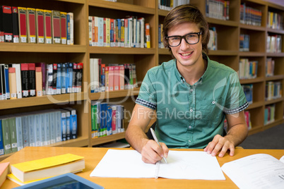 Student sitting in library writing