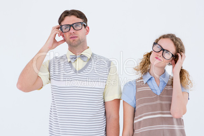 Geeky hipster couple thinking with hand on temple