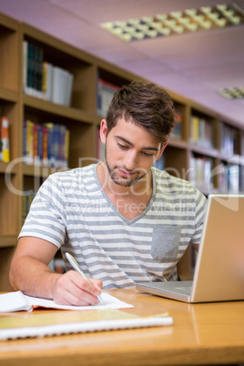 Student studying in the library with laptop