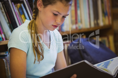 Little girl reading on library floor