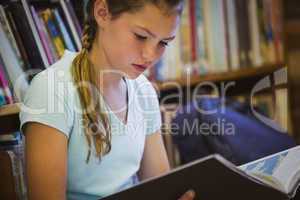 Little girl reading on library floor