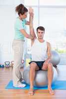 Man stretching his arm with trainer