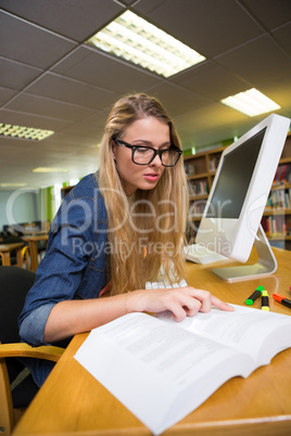 Student studying in the library with computer