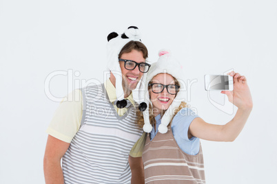 Geeky hipster couple taking selfie with smartphone