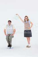 Geeky hipster holding watering can above her boyfriend