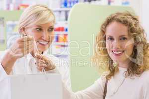 Pharmacist and costumer holding paper bag