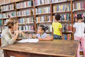 Teacher helping pupil in library