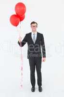 Happy geeky hipster businessman holding balloons