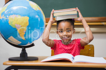 Cute pupil holding books on her head