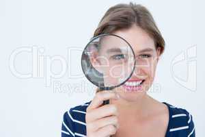 Smiling woman holding magnifying glass