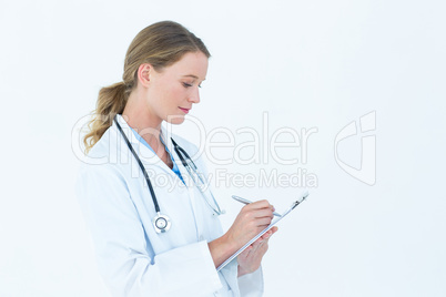 Doctor writing on clipboard