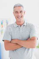 Smiling doctor standing arms crossed and looking at camera