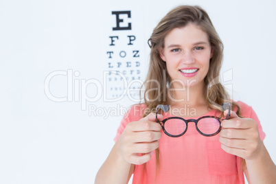 Hipster showing glasses next to an eye test