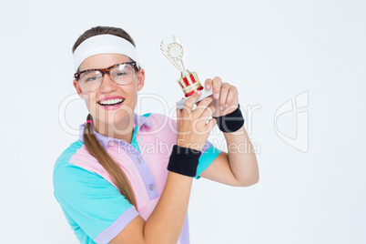 Geeky hipster holding winners trophy