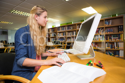 Student studying in the library with computer