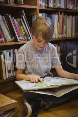 Little boy reading on library floor