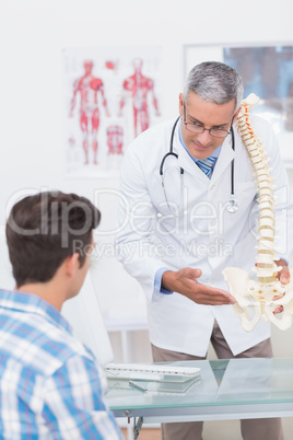 Doctor explaining a spine model to patient