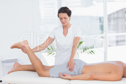 Physiotherapist doing leg massage to her patient